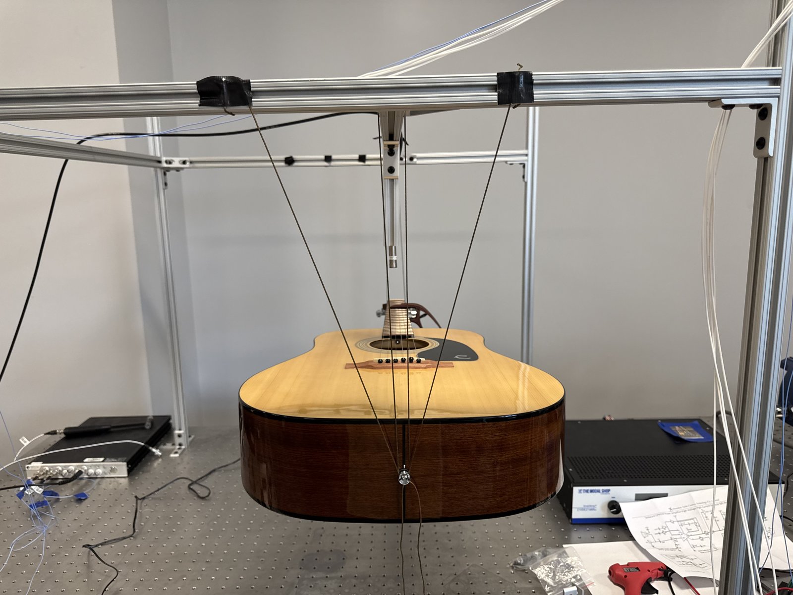 Acoustic guitar suspended in a free-free boundary rig for impact testing
