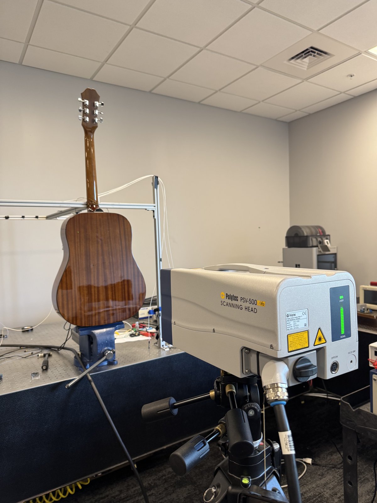 Polytec PSV-500 scanning head aimed at a guitar body clamped for LDV scanning