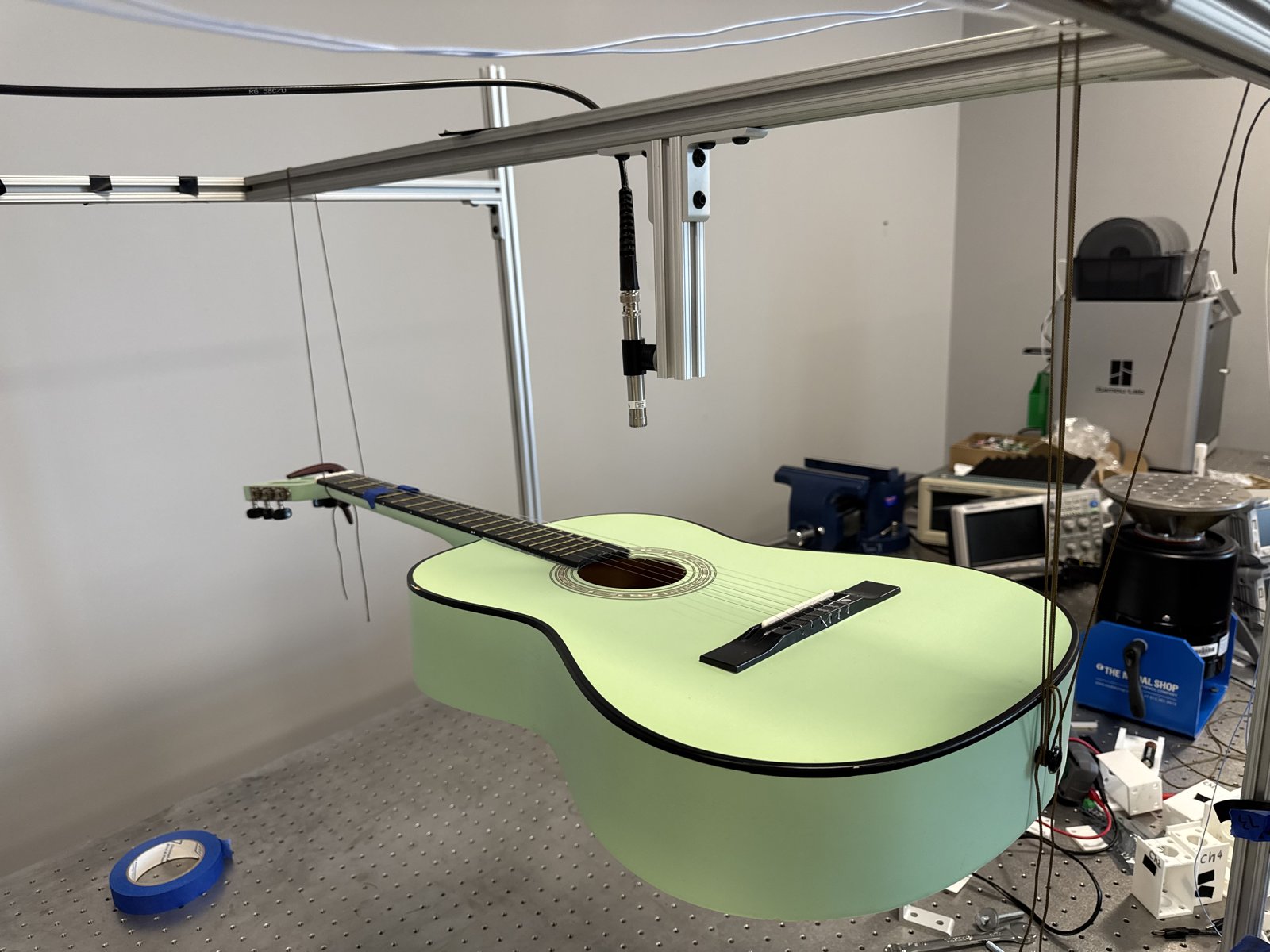 Guitar suspended under a Laser Doppler Vibrometer with a modal shaker attached